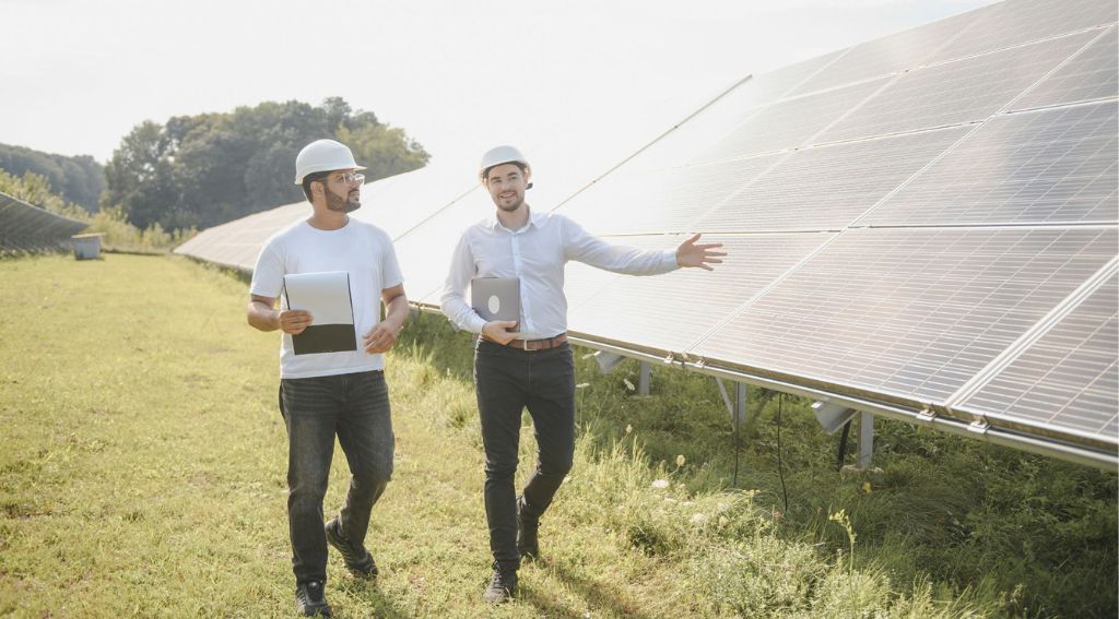 Zwei Männer mit Bauhelmen begutachten eine Solaranlage
