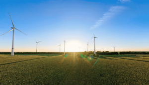 Eine Landschaft mit vielen Windkraftwerken und Sonnenuntergang.